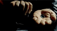 Two open hands offering a red pill and a blue pill against a dark background